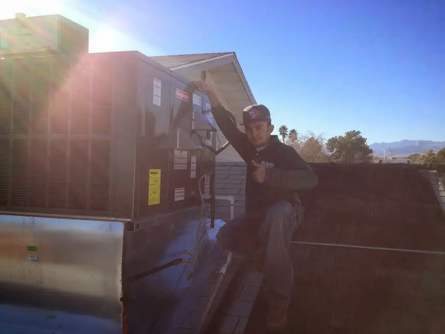 HVAC technician performing AC Tune-Up on a rooftop unit in Navasota